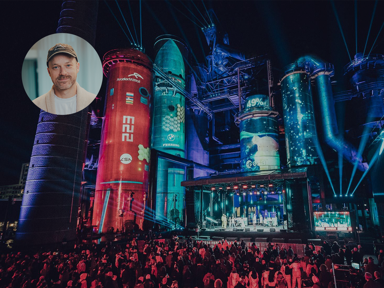 Crowd stands in front of a stage in an illuminated industrial area at Esch2022 Opening Ceremony organized by Battle Royal Studios with Brendan Shelper