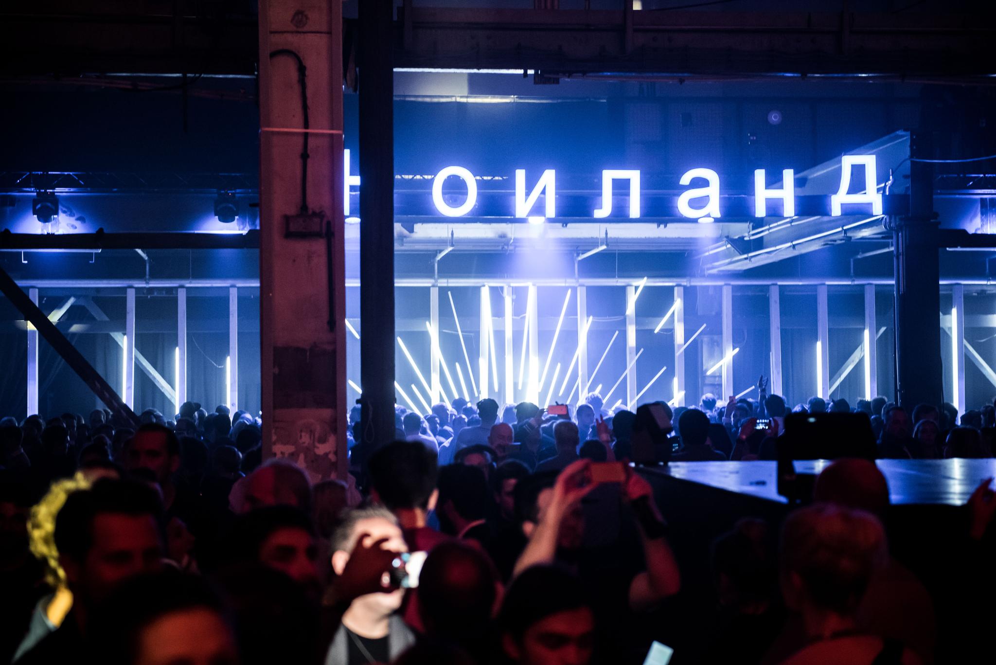 A full dancefloor with bright Cyrillic writing and LEDs.