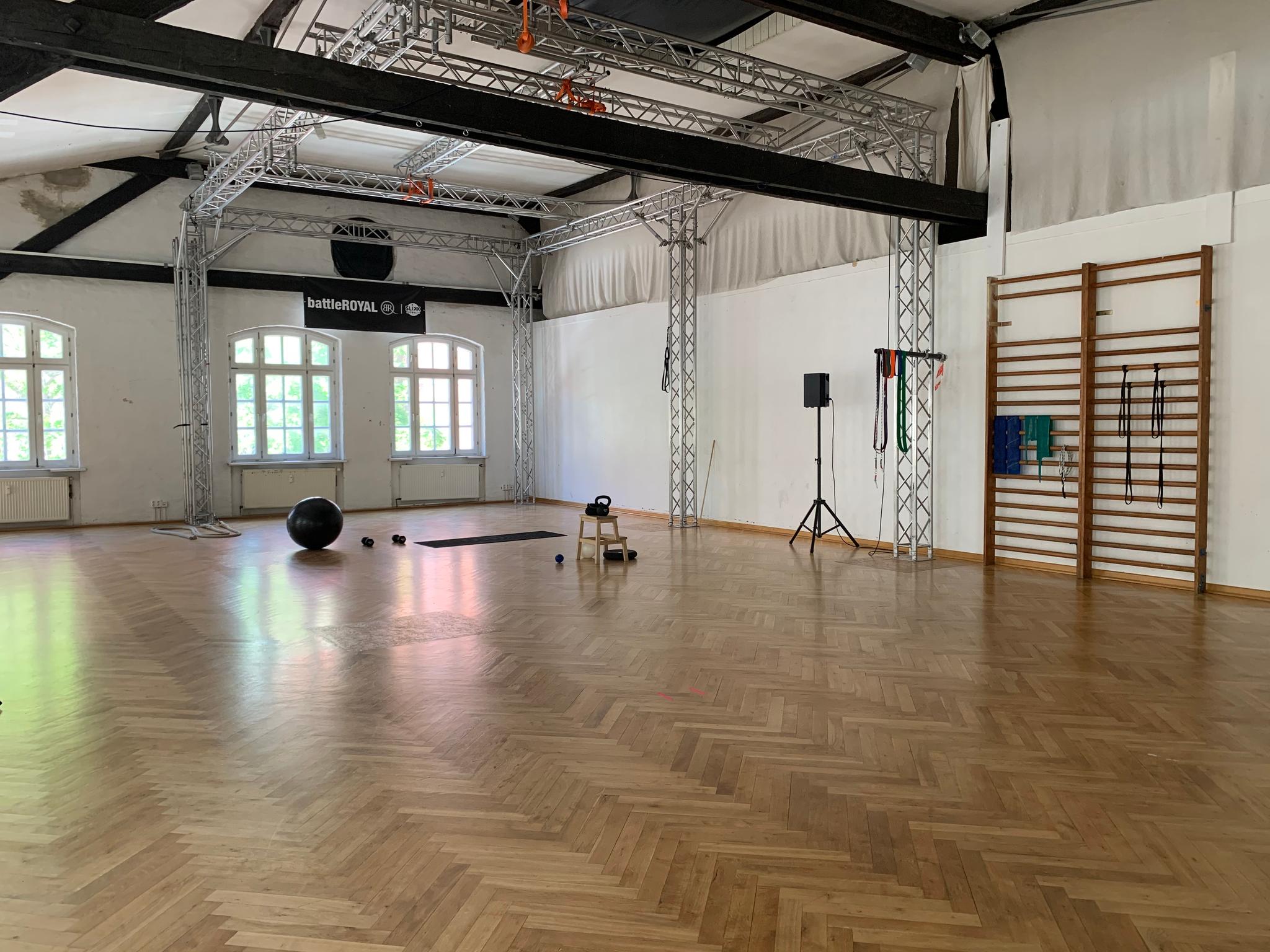 Wide shot of the studio space with yoga equipment on the floor.