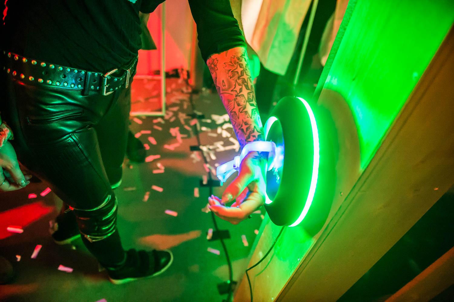 A person in leather pants scans their glowing white wristband.