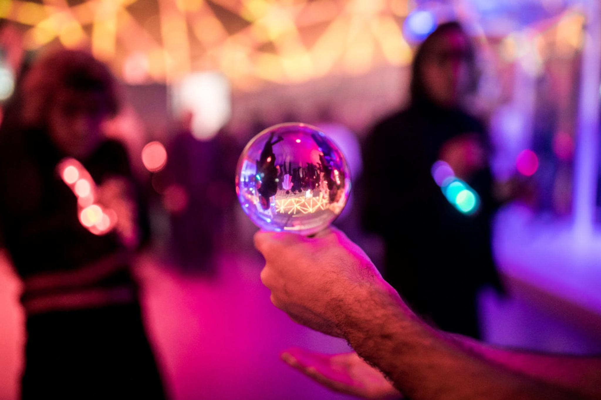 A performer holds a glass ball in their hand.