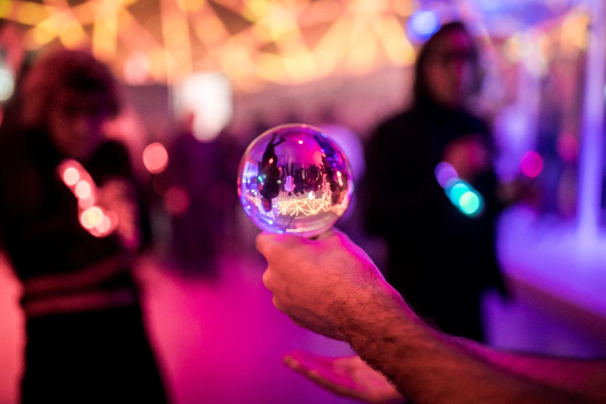 A performer holds a glass ball in their hand.