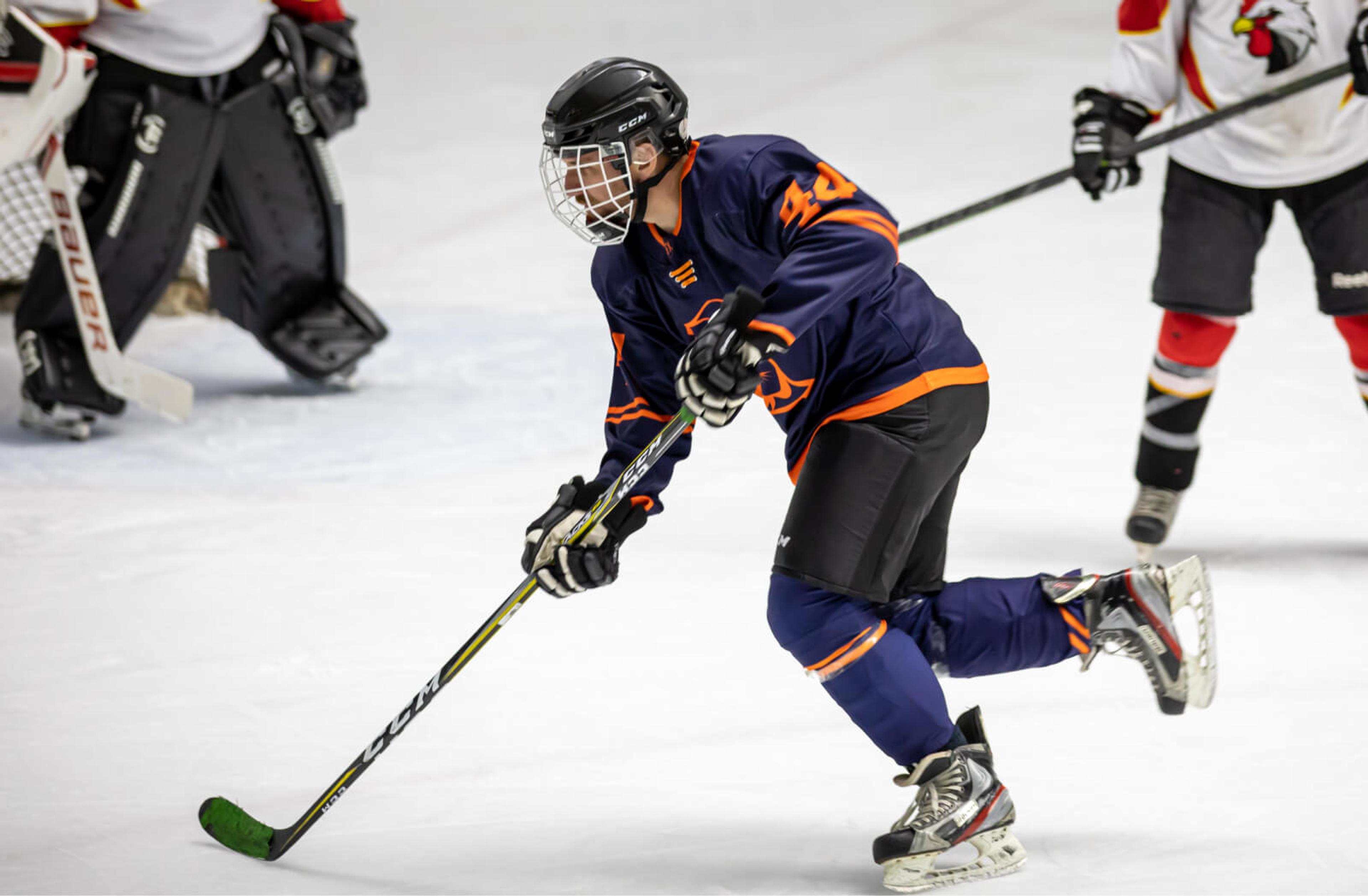 A hockey player in a navy and orange uniform.