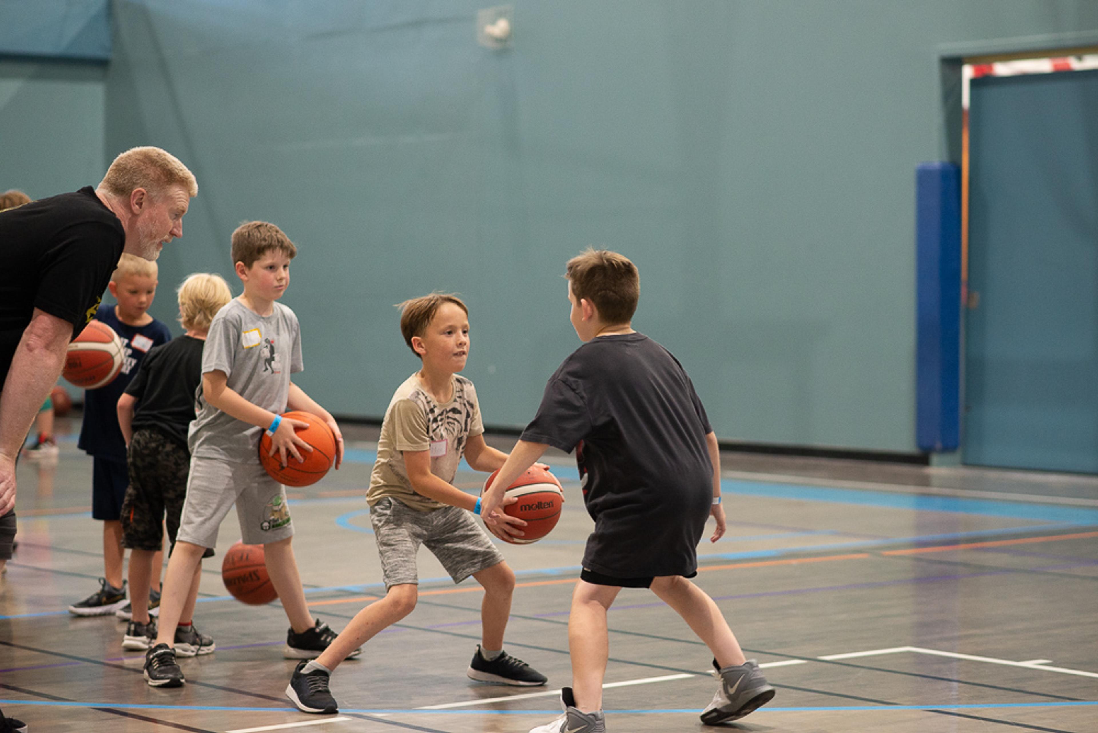 A group of children practicing a basketball drill at the SLS Centre.