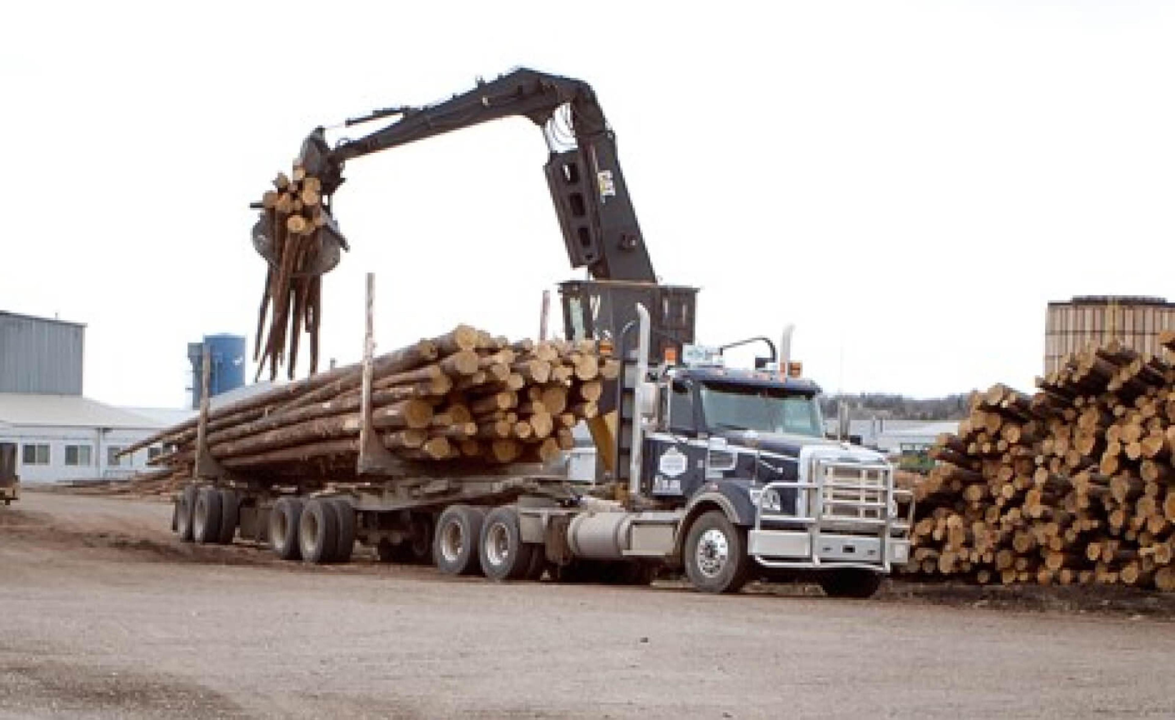 A semi truck loading up with lumber.