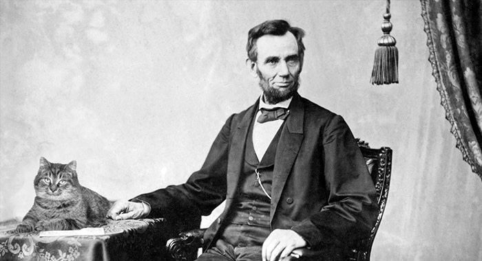 Old looking black and white photograph of abraham lincoln and a cat sitting on the table next to him