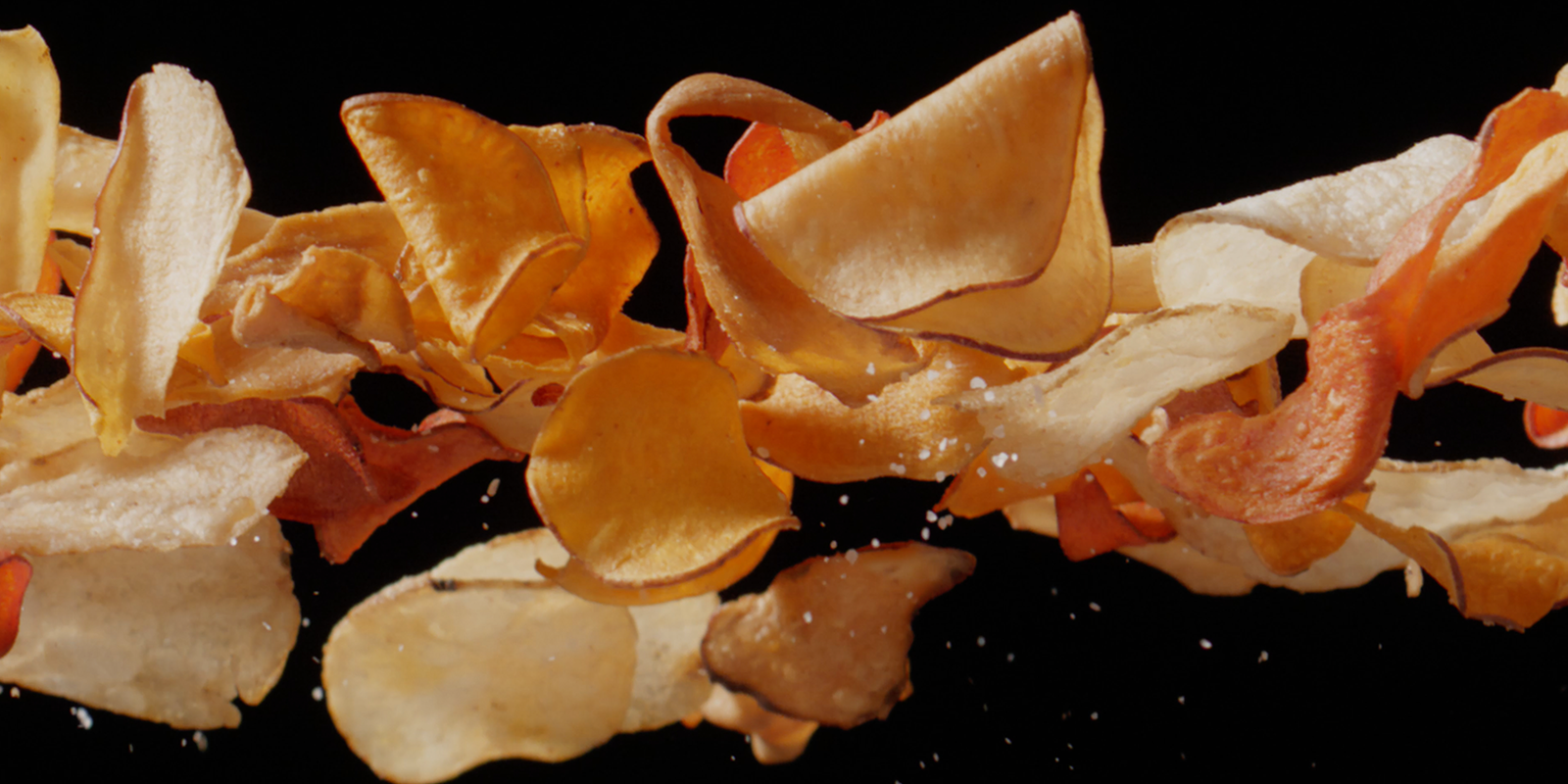 Terra potato chips fly across the screen in front of a black background