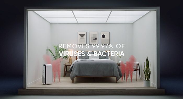 A square shot of a set of a bedroom with text that reads, "removes 99.97% of viruses and bacteria"