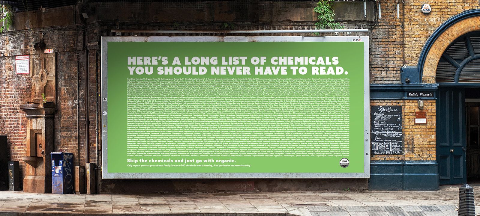 A large sign on the wall on top of a brick wall with a long list of chemicals that are found in things we consume