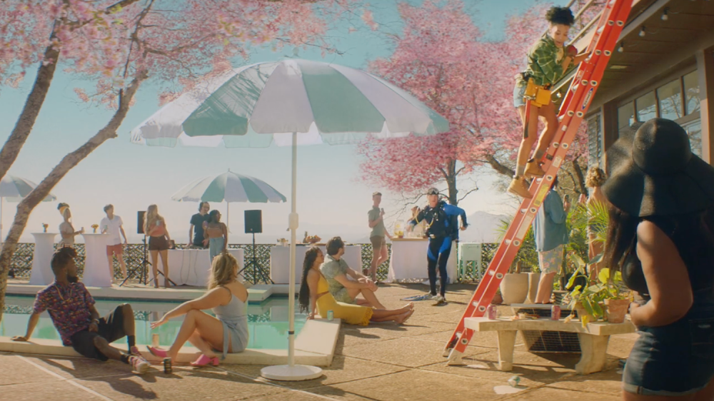 Scene of a backyard pool party and a woman dropped a drink from the top of a ladder accidentally