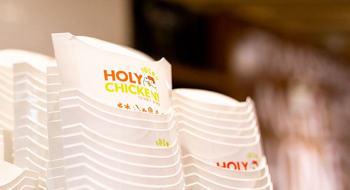 A stack of Holy Chicken fry containers