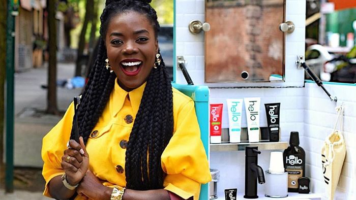 A woman in a yellow shirt smiles in front of the mobile hello teeth brushing station