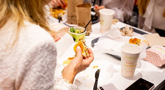 a shot from over the shoulder of a woman eating a holy chicken sandwich