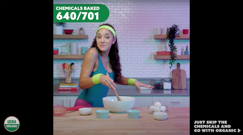 A woman in workout clothes and sweatbands mixes cake batter in a kitchen