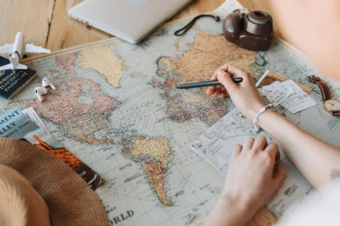 A world map surrounded by travel planning items