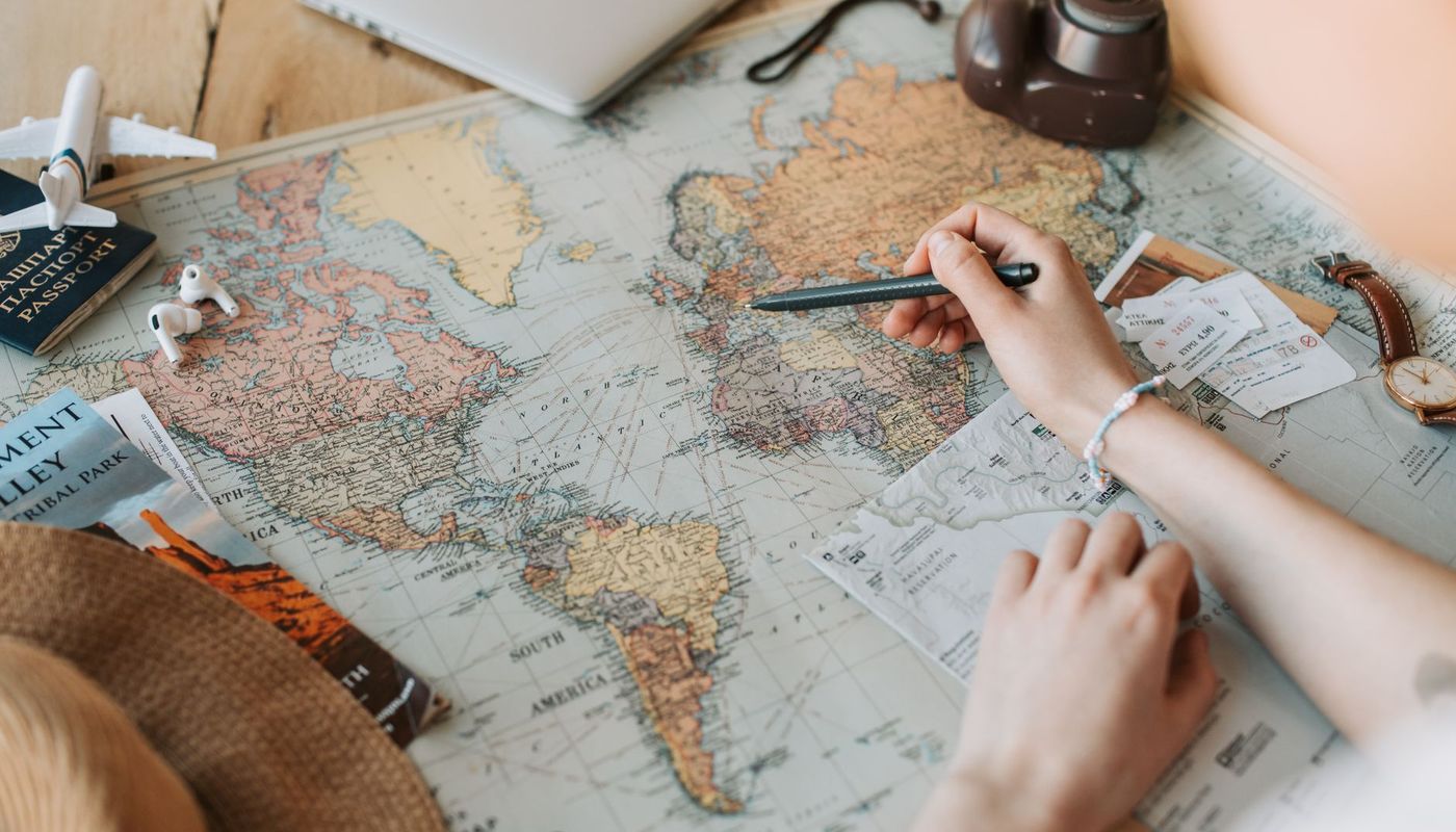 A world map surrounded by travel planning items