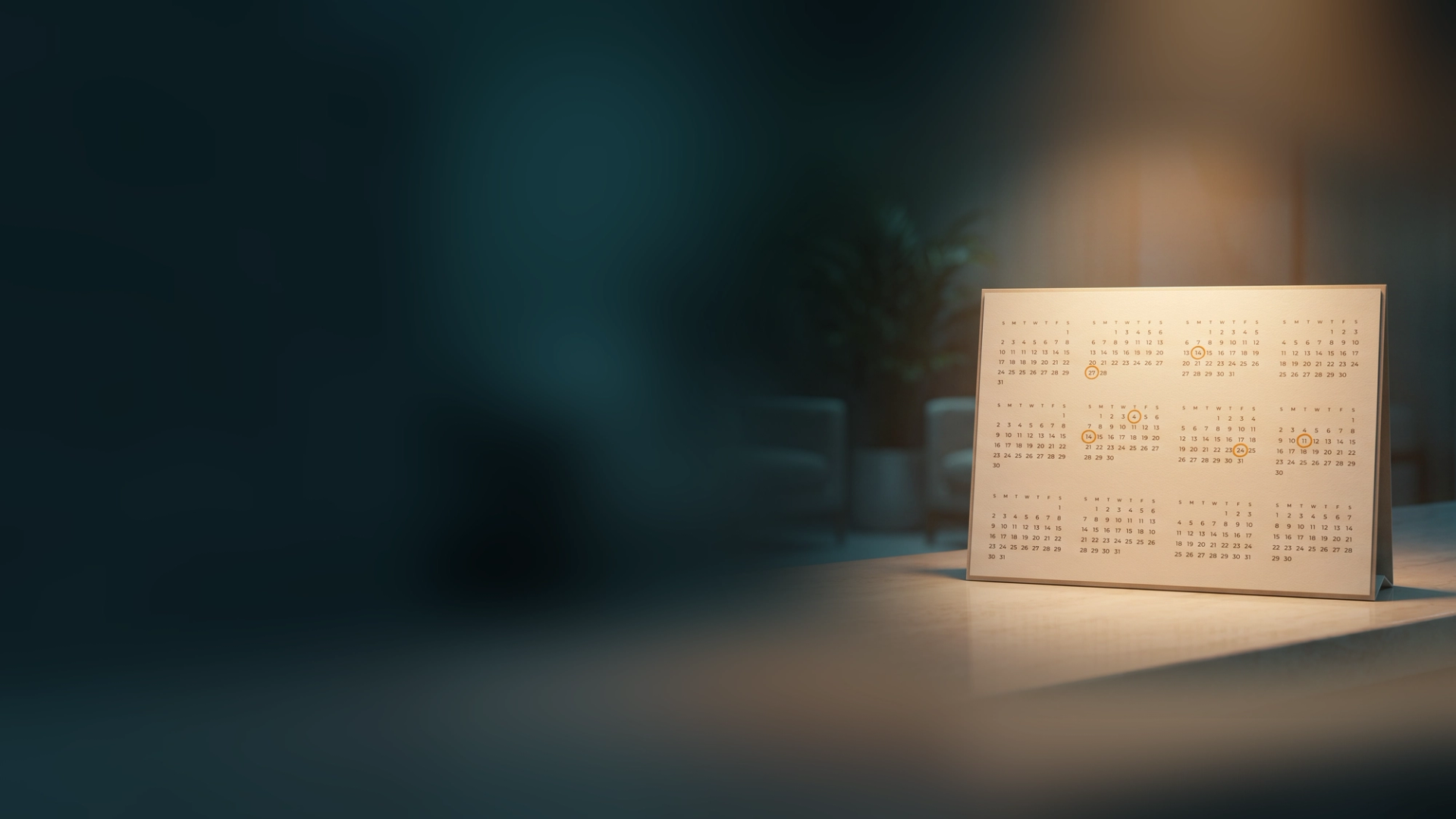 A year-at-a-glance desk calendar on a reception counter with several appointment dates circled in amber
