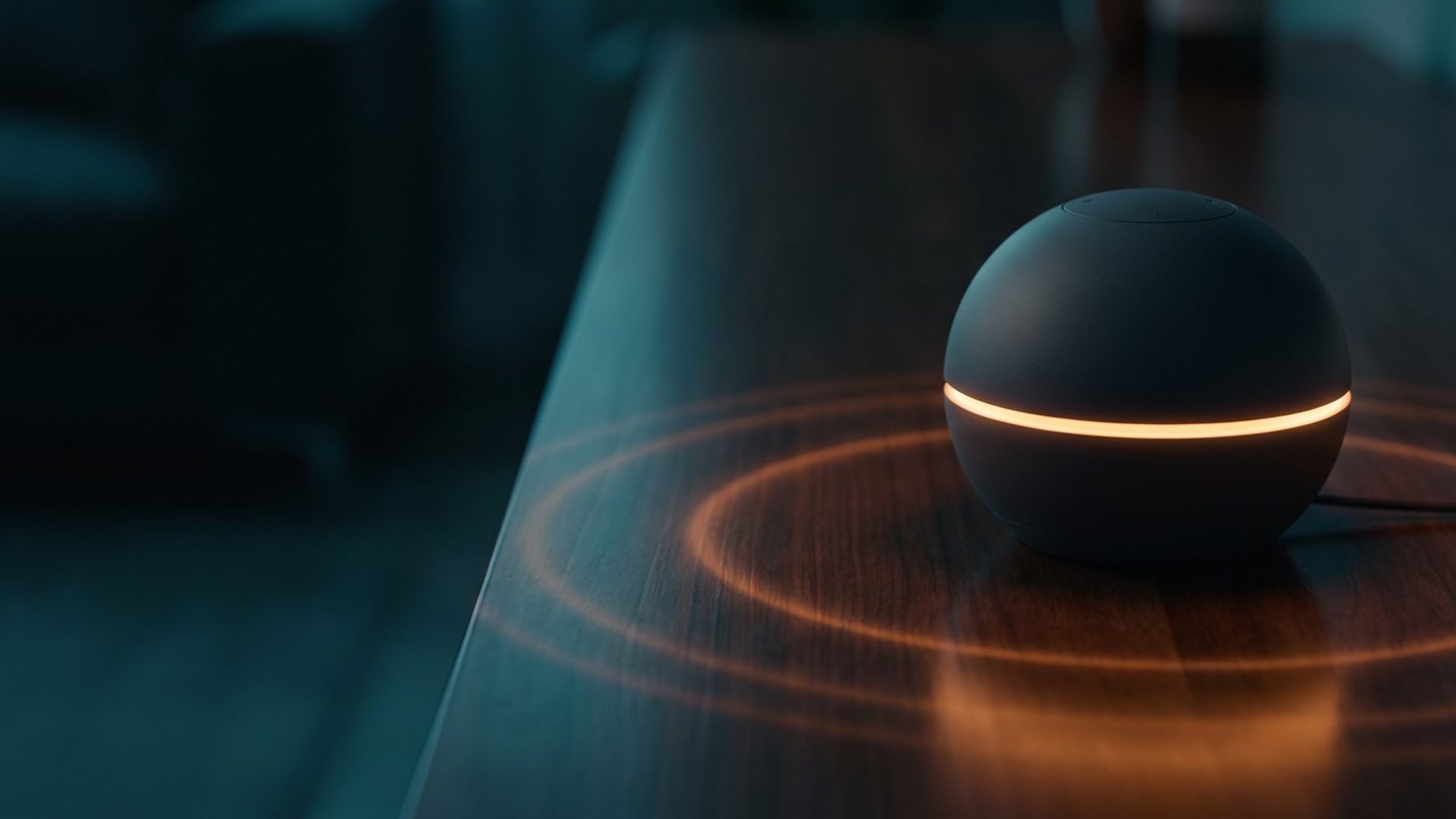 A black smart speaker with a glowing amber ring sitting on a dark wooden table, rings of light spreading across the surface around it.