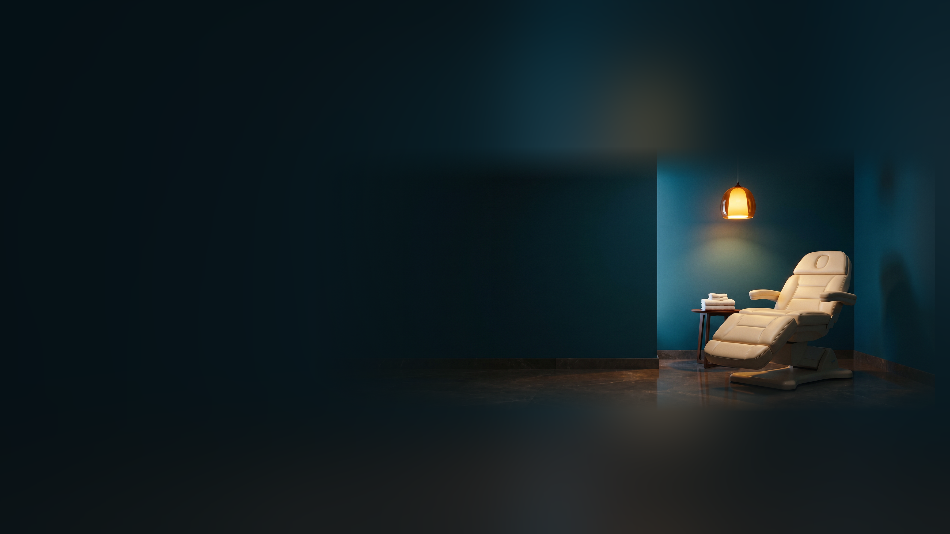 An empty med spa treatment room with a padded treatment chair under a warm pendant lamp