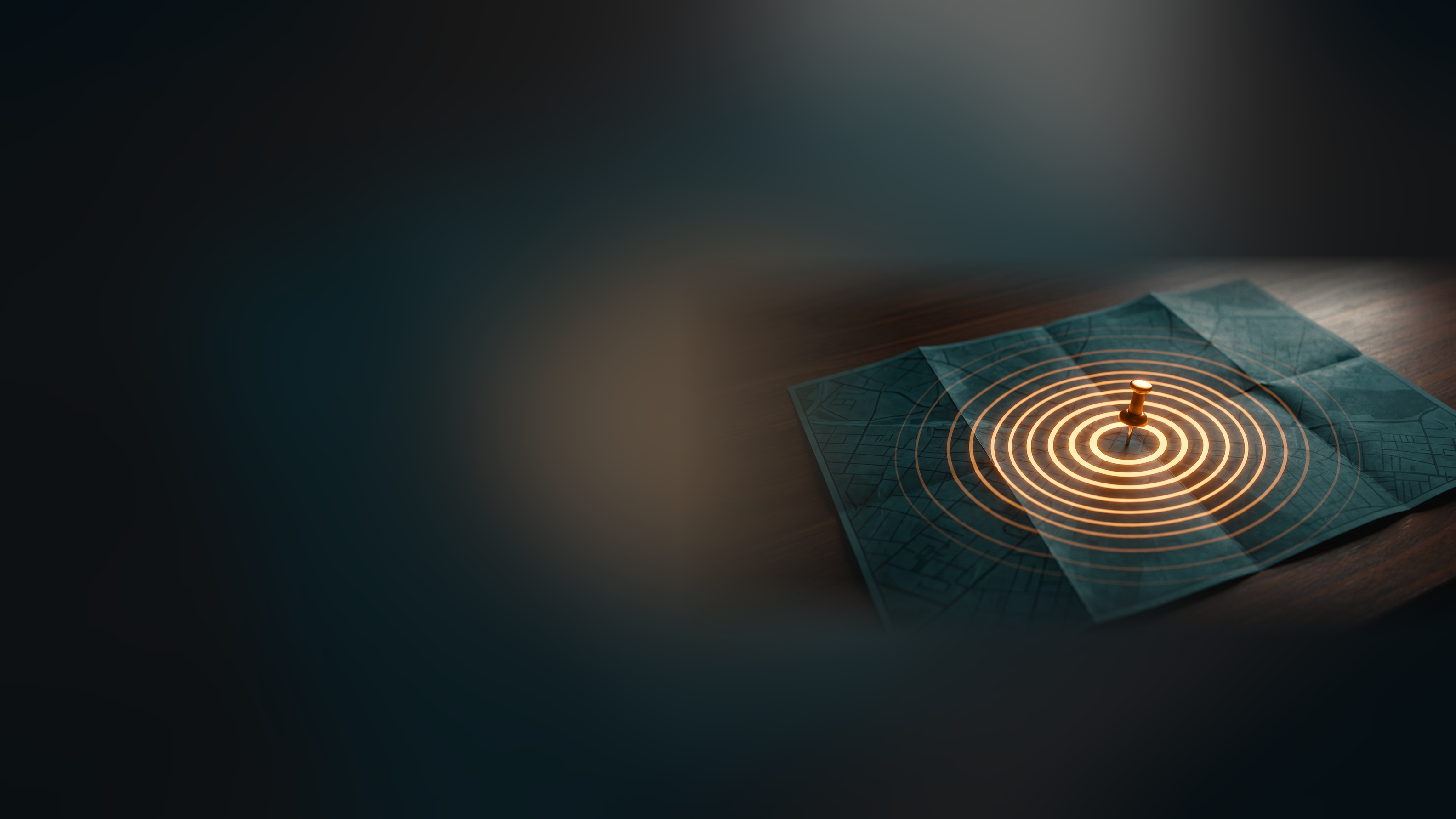 A pushpin in a folded city map on a dark desk, with glowing amber rings spreading out from it