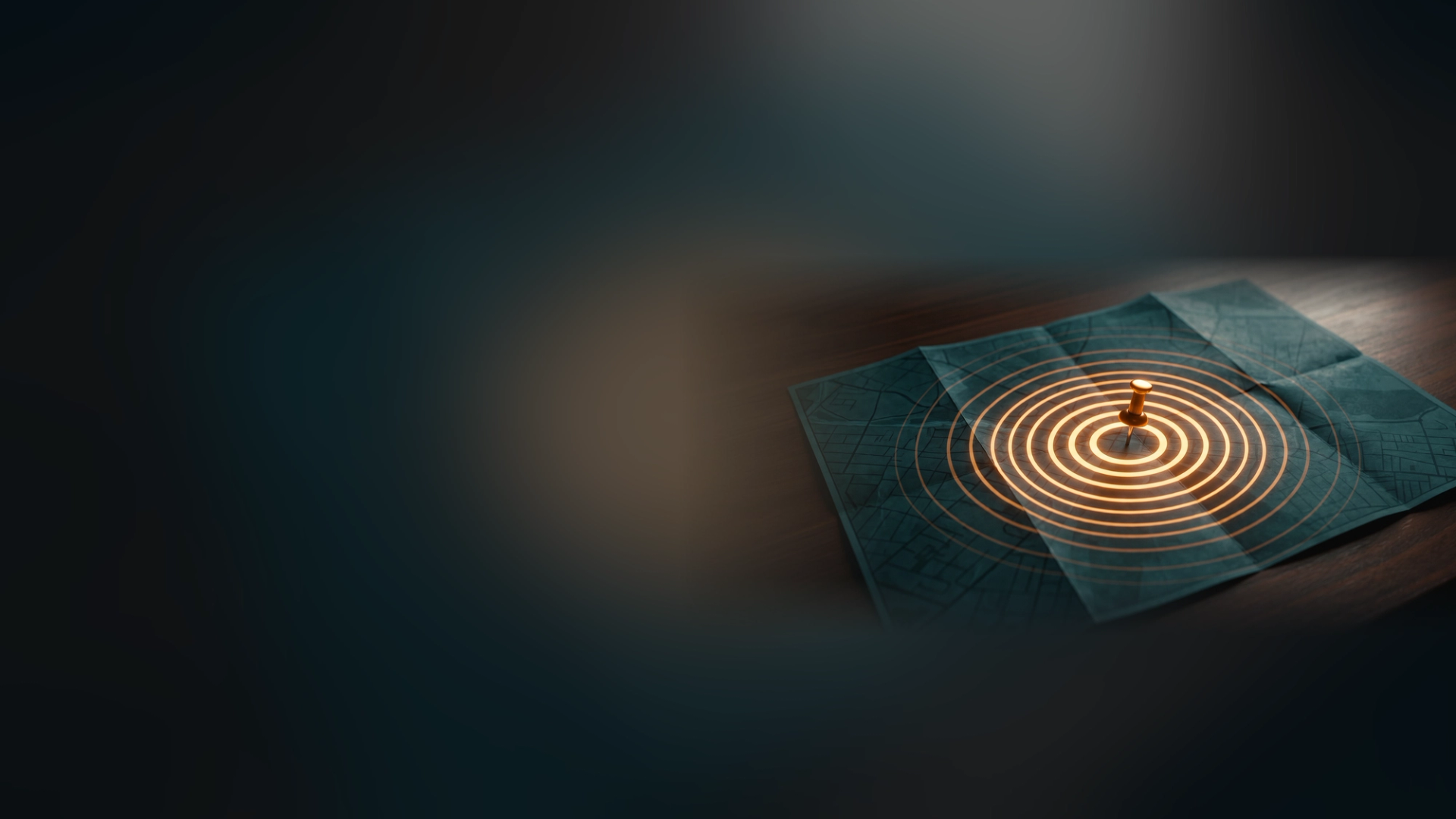 A pushpin in a folded city map on a dark desk, with glowing amber rings spreading out from it