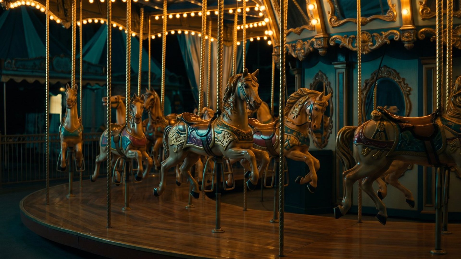 An ornate carousel at night, its carved horses lit in a row along the deck