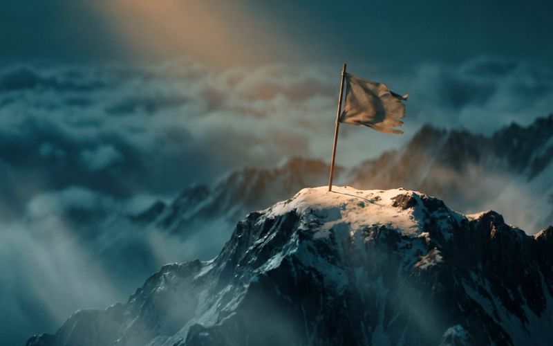 A single flag planted on a dramatic mountain summit at amber dawn, deep teal clouds in the valley below - the objective reached.