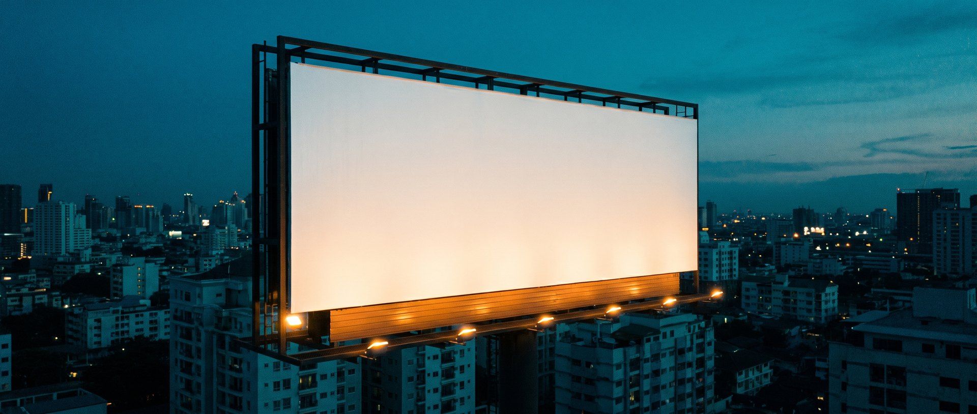 A large billboard in a prime position over a city at dusk, perfectly lit but with a completely blank face -- the placement is right, the ad says nothing.