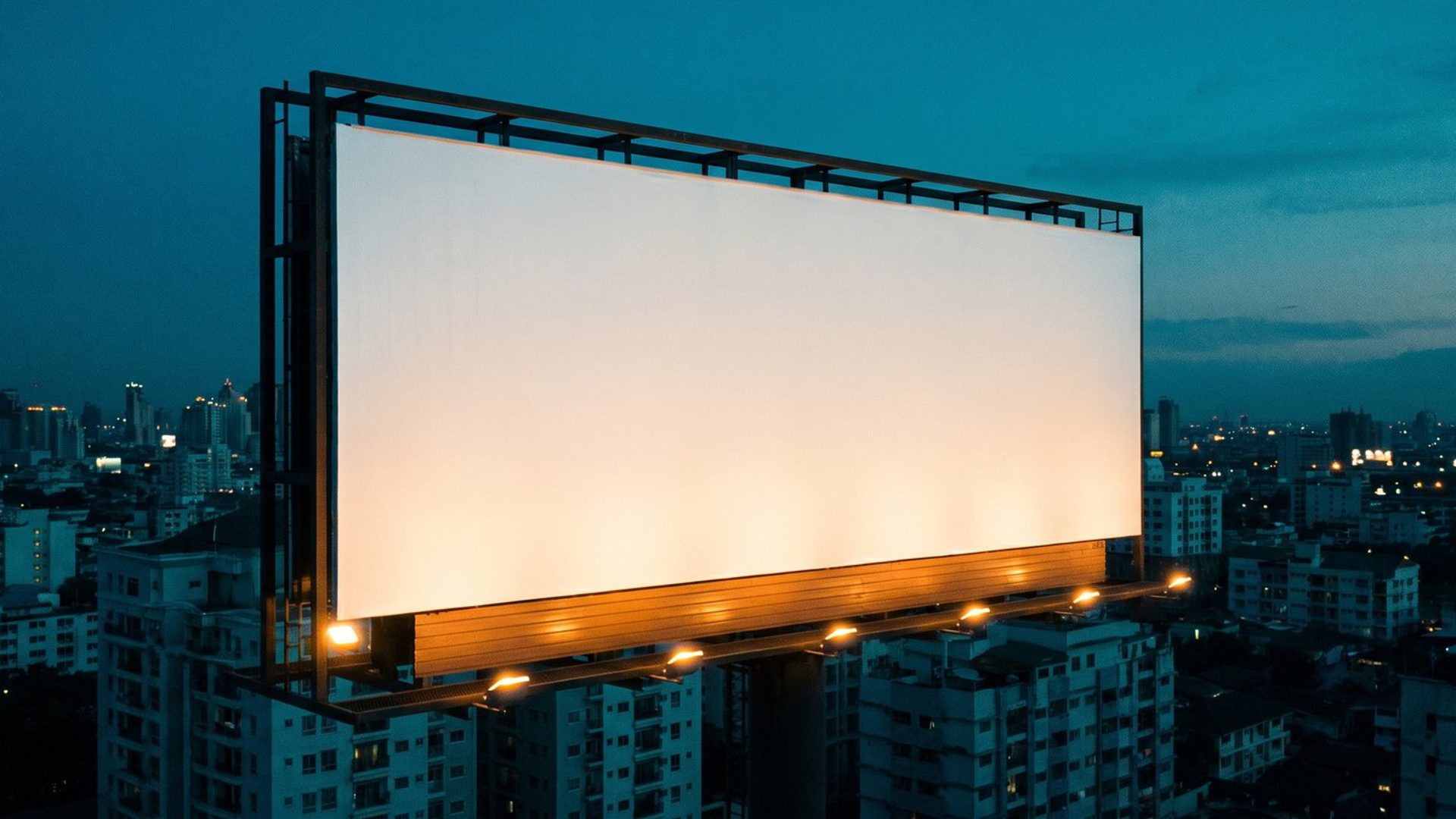 A large billboard in a prime position over a city at dusk, perfectly lit but with a completely blank face -- the placement is right, the ad says nothing.