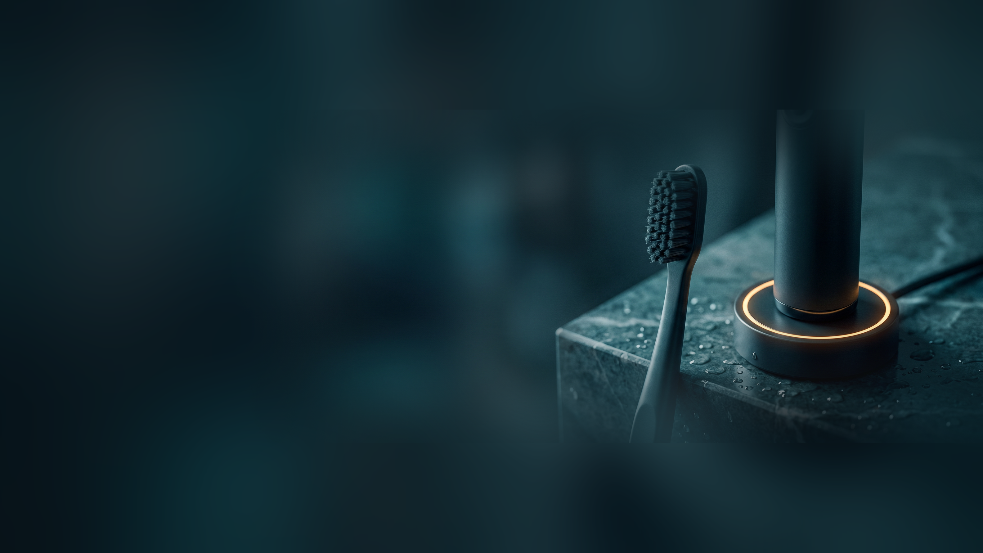 A plain manual toothbrush beside an electric toothbrush glowing on its charging base, close up on a dark stone counter