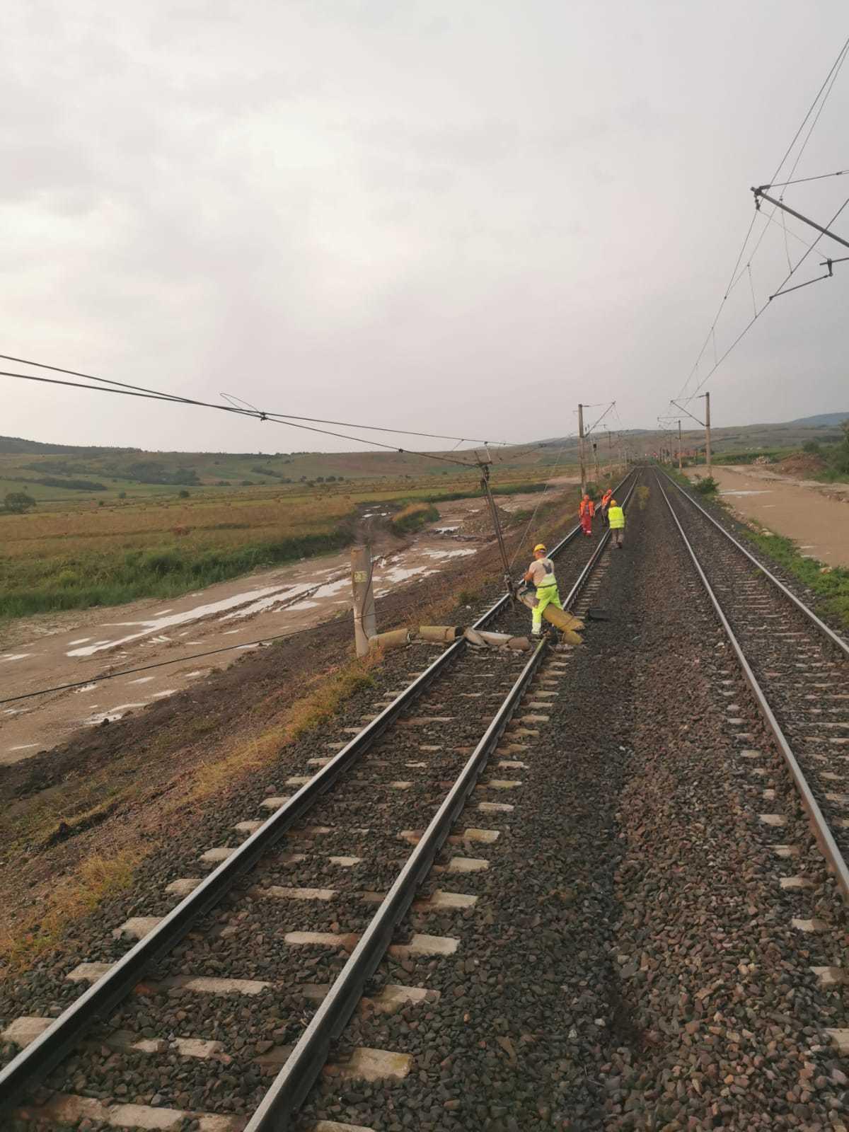 Stâlp prăbuşit pe calea ferată, în judeţul Braşov, un tren de călători fiind staţionat / Se lucrează pentru îndepărtare