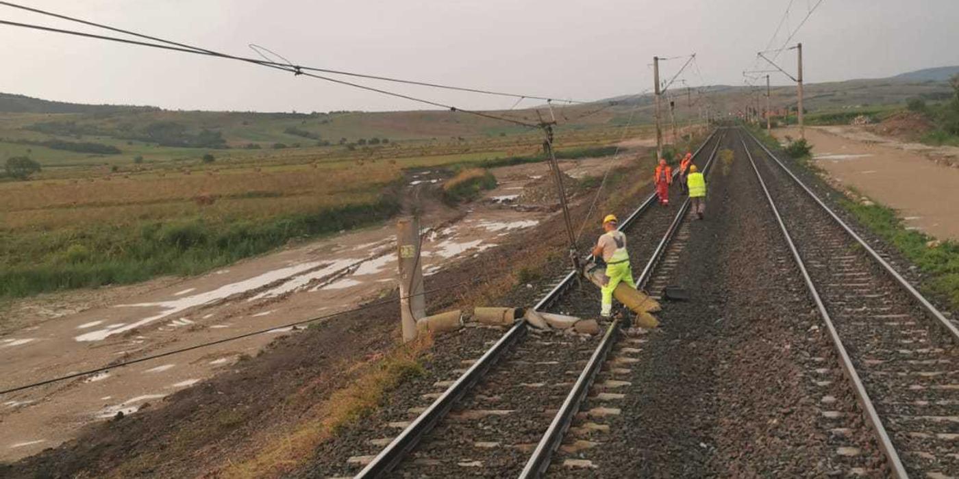 Stâlp prăbuşit pe calea ferată, în judeţul Braşov, un tren de călători fiind staţionat / Se lucrează pentru îndepărtare