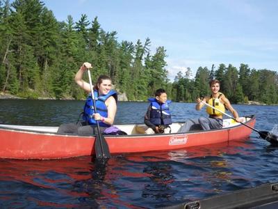 staff and camper canoeing and smiling at Canadian Adventure Camp