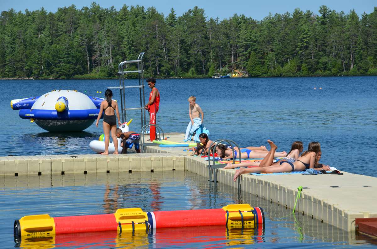 campers lying in the sun while lifeguard watches at Canadian Adventure Camp