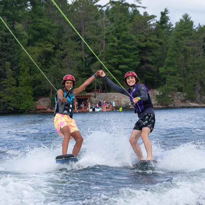 Campers wake-boarding on the lake.