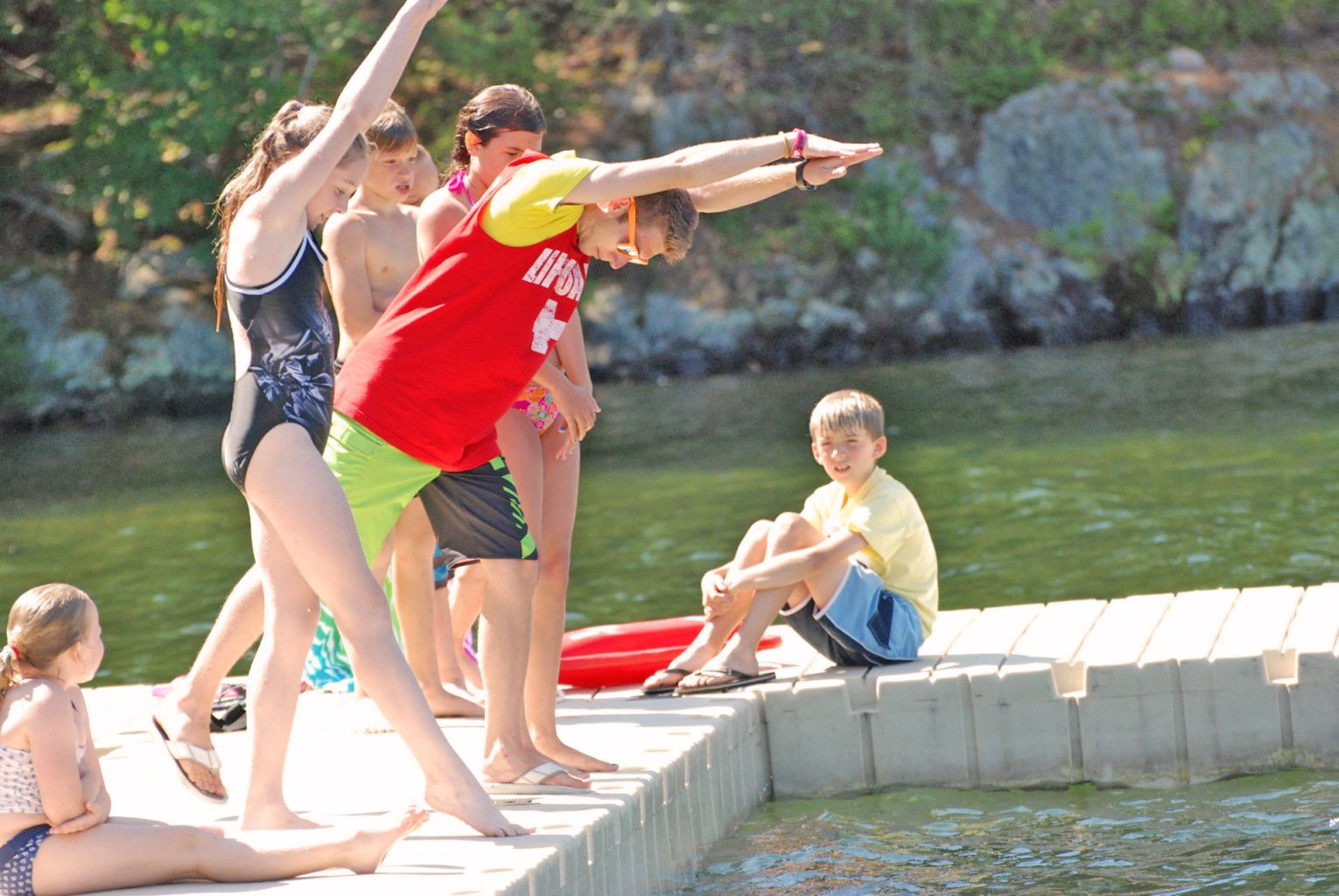 four teen campers with wearing Canadian Adventure Camp hoodies smiling at the camera