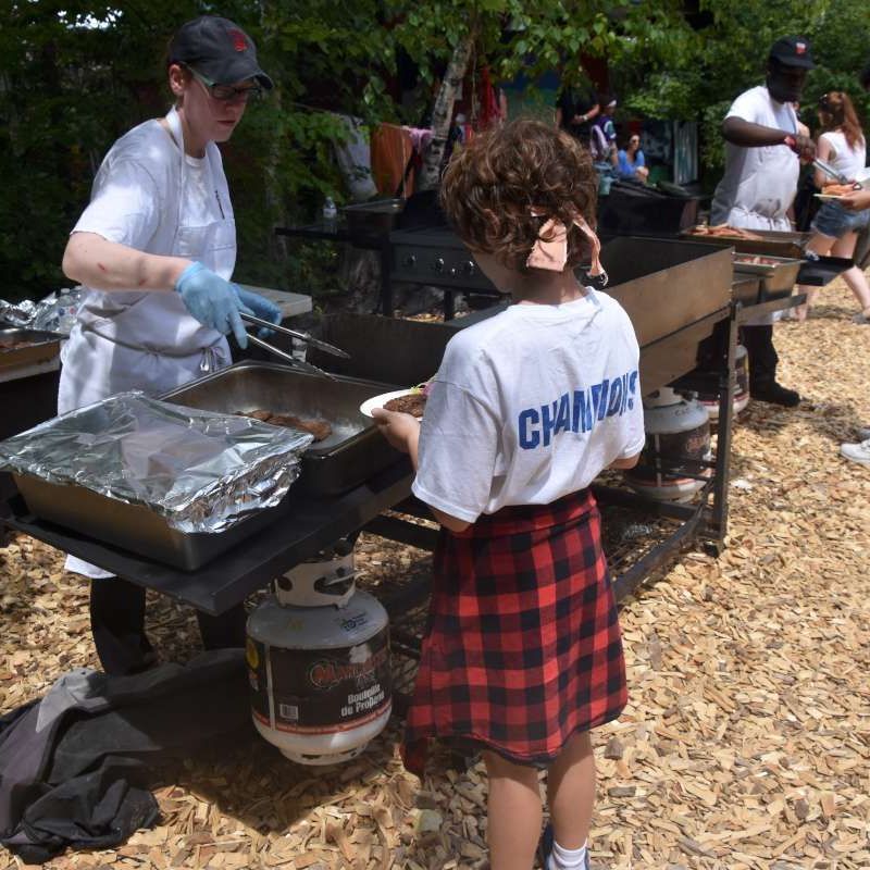 Child getting served bbq lunch outside at Canadian Adventure Camp