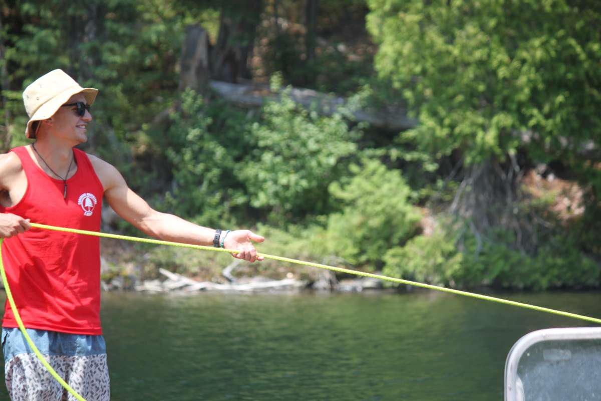 camp lifeguard pulling a boat in at Canadian Adventure Camp
