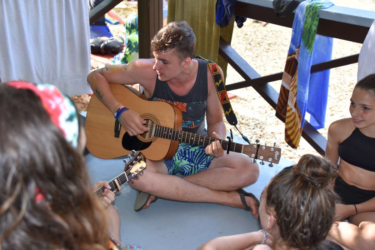 camp counsellor playing the guitar at Canadian Adventure Camp