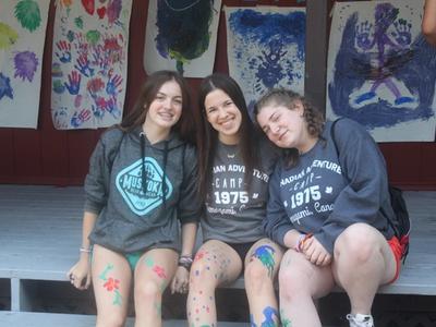 three campers smiling with body paint