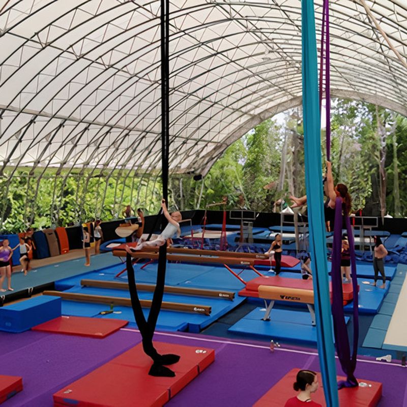 Camper on the silks upside down in the gym at Canadian Adventure Camp