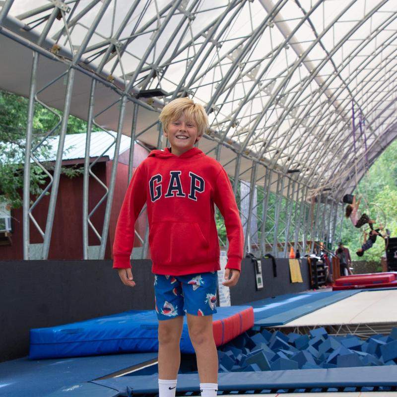 Camper mid-jump on a trampoline.
