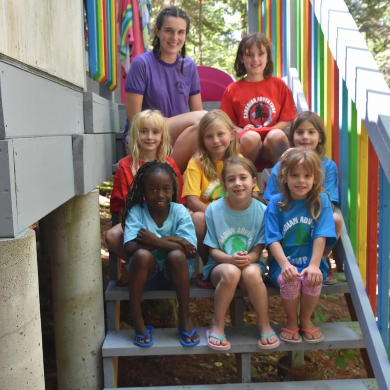 counsellor with group of campers smiling at the camera