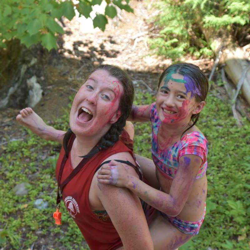 counsellor and camper covered in body paint smiling at the camera at Canadian Adventure Camp