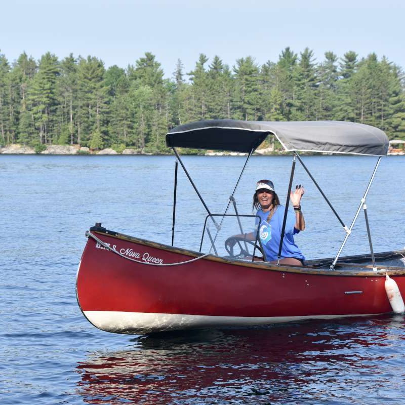 staff driving a camp boat on the lake at Canadian Adventure Camp
