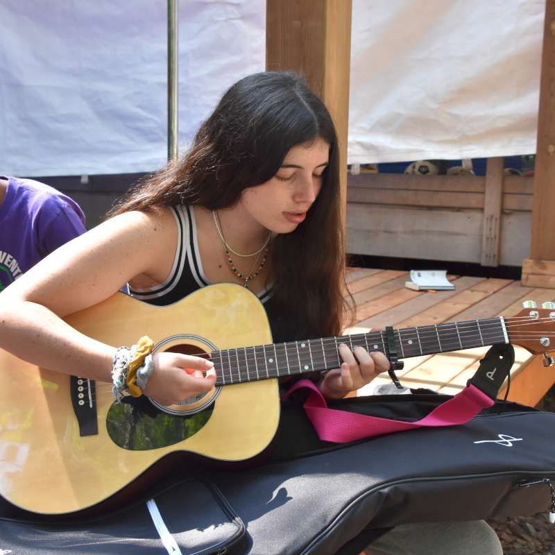 camper playing guitar at Canadian Adventure Camp