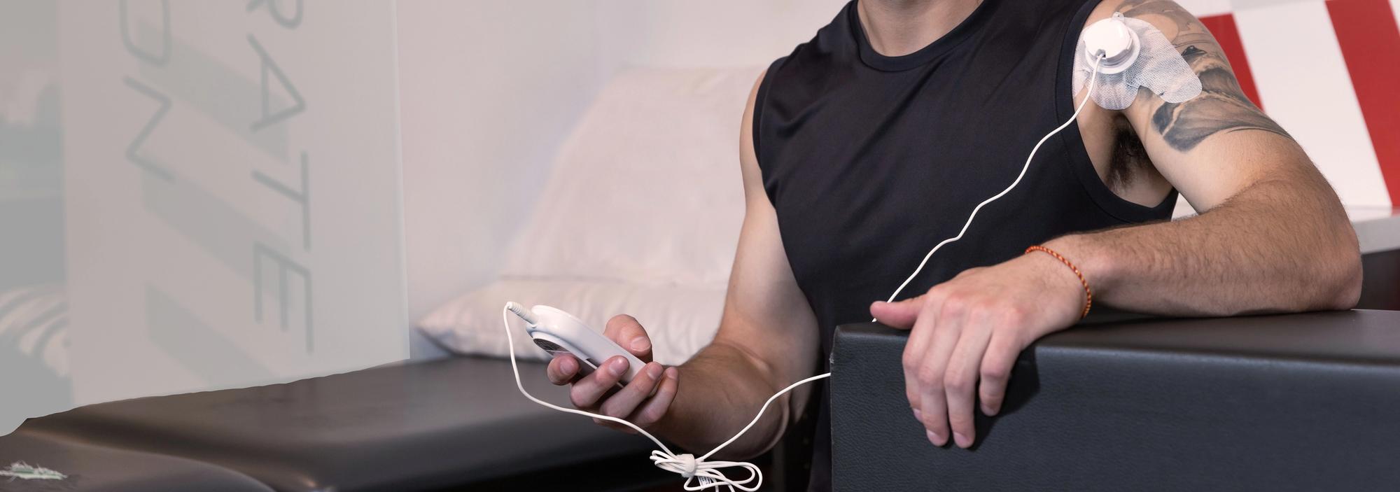 An athlete holding a ManaSport+ ultrasound unit.