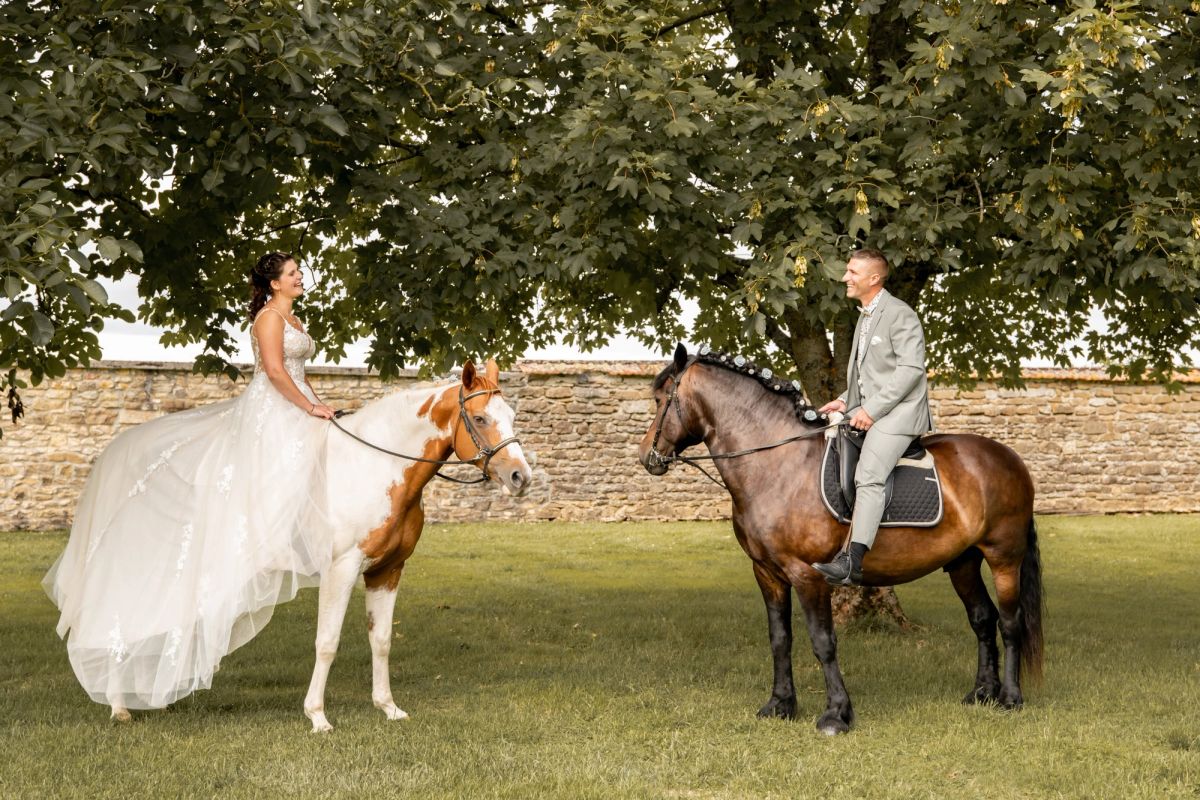 Mariés à cheval sous un grand arbre, séance de couple en extérieur dans l’Aube
