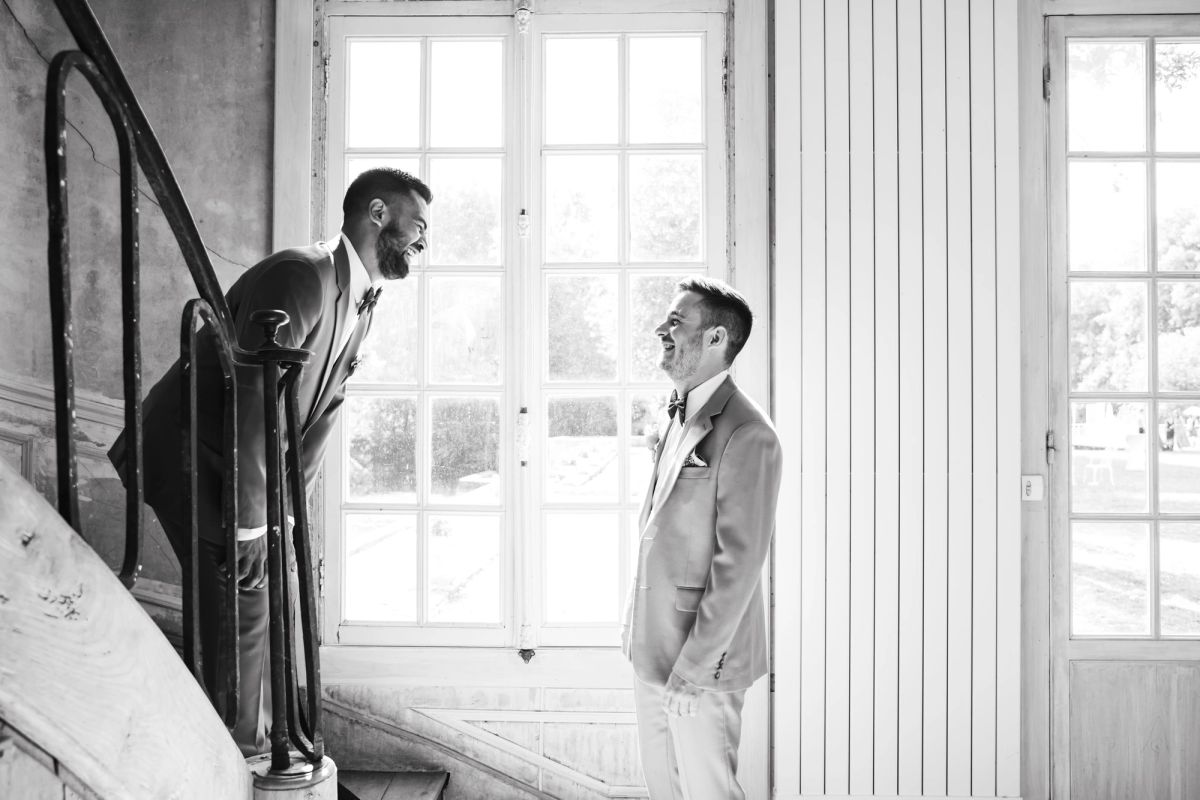 Deux hommes se faisant face de part et d’autre d’une fenêtre, préparatifs en noir et blanc