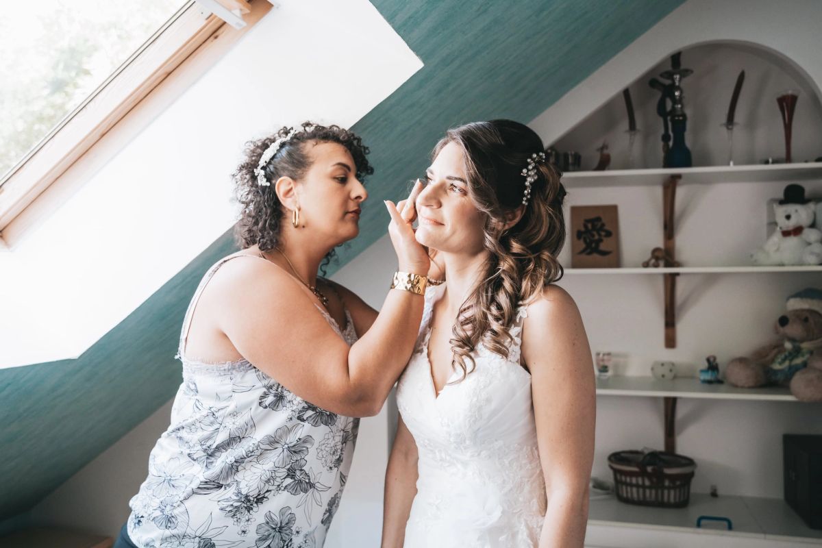 Préparatifs de la mariée, une proche ajuste son maquillage